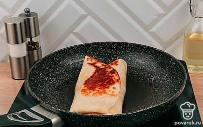 Попробуйте завернуть лепешку «конвертом», один край должен остаться открытым. Обжариваем тортилью на сковородке.