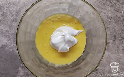 К молочной смеси добавьте муку и введите по 1 желтку. Тщательно перемешайте с помощью венчика. Белки взбейте до твердых пиков, добавьте сахар и продолжайте взбивать до пышной массы. Соедините тесто с суфле и осторожно перемешайте.