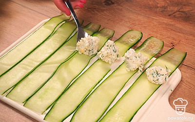 Огурцы промокните от лишней влаги бумажными салфетками. Смешайте творожный сыр с чесноком и яйцом. Порубите зелень и добавьте к сыру с яйцом. Посолите, поперчите. Чайной ложкой выложите на край огуречных полосок творожный сыр с зеленью и яйцом. Сверните рулеты из огурцов.