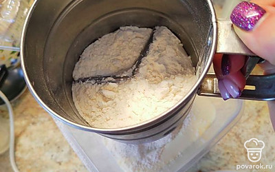 Просейте в яичную массу муку и мешайте ложкой, чтобы воздух не вышел.