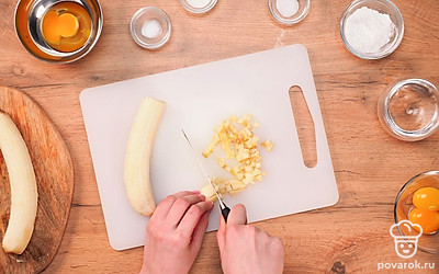 Включите духовку. Температура выпекания составляет 180 градусов. Смажьте форму маслом и посыпьте ее манной крупой. Вымойте и очистите бананы. Их нужно нарезать мелкими кубиками. Яйца нужно вымыть и высушить. Желтки и белки 2 яиц отделите в разные емкости. Муку с разрыхлителем просейте через сито. Подготовьте миксер и силиконовую лопатку.