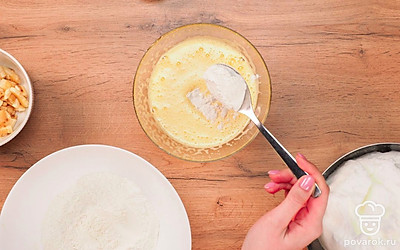 Продолжайте готовить основу для бисквита с бананом. Добавьте к желткам муку с разрыхлителем и перемешайте.