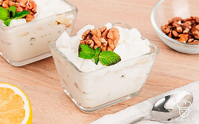 Сливочный десерт украсьте грецкими орешками и листочком мяты.
