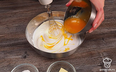 Чтобы коржи для торта получились воздушными и вкусными, аккуратно соедините белковую и желтковую смеси. Миксер при этом выключать не нужно.