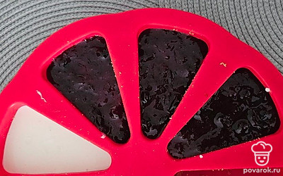 Вылейте варенье на молочную смесь. Уберите форму в холодильник на 20 минут.