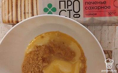 Печенье измельчить в мясорубке или пробить блендером. Добавить размягченное сливочное масло, перемешать.