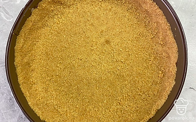 Распределите печенье с маслом по форме для чизкейка, делая бортики. Поставьте выпекаться на 5 минут при 180 градусах.