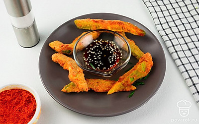 Подайте авокадо на плоской тарелке, поставив в центр пиалу с соевым соусом и кунжутом.