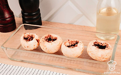 Ножки шампиньонов отделите от шляпок. Мякоть шампиньонов удалите ложкой или ножом — так начинки поместится больше.