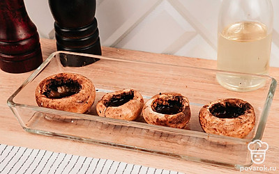 Шляпки грибов выложите в форму для запекания, предварительно смазанную маслом. Поместите форму в духовку и запекайте грибы 10 минут при 180 °С.