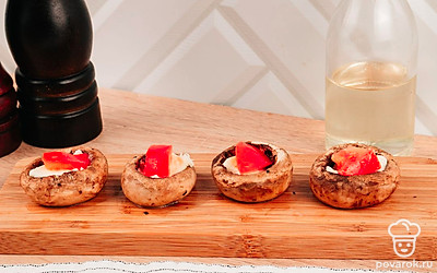 Достаньте грибы из духовки и нафаршируйте их в такой последовательности: чеснок, моцарелла, помидоры.