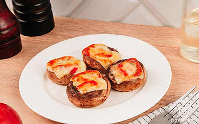 Горячие фаршированные грибы легко заменят полноценный обед или ужин, в холодном виде такие грибы можно подать на листьях салата или подушке из руколы.