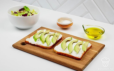 Порежьте авокадо тонкими ломтиками и выложите сверху на творожный сыр.