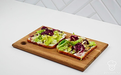 Микс салатов сбрызните оливковым маслом и выложите сверху на авокадо.