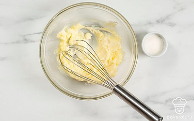 Добавьте к маслу обычный и ванильный сахар, а затем хорошо перемешайте массу венчиком.