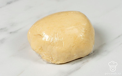 Всыпьте сухие ингредиенты в яично-сметанную массу. Перемешайте и замесите однородное эластичное тесто, которое не будет прилипать к рукам. Затем оберните его пищевой пленкой и уберите в холодильник на 30 минут.