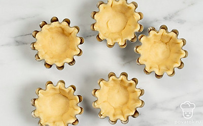 Выложите заготовки в формы для корзинок и распределите их по всей поверхности.