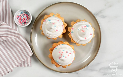 Посыпьте корзинки с кремом кондитерской посыпкой. После этого подайте десерт на стол.