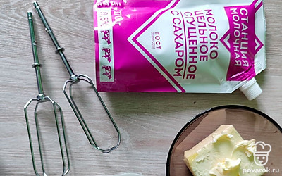 Остывший бисквит крошим на мелкие кусочки. Сливочное масло и сгущенку взбиваем миксером до однородности. 