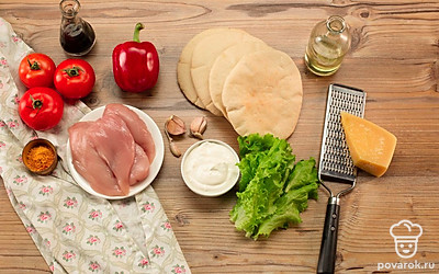 Куриное филе и листья салата нарежьте полосками, помидоры и перец — дольками. Мелко натрите сыр и чеснок.