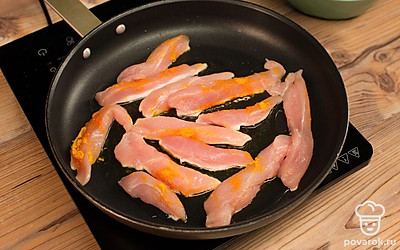 Полоски куриного филе посыпьте куркумой, солью и хорошо перемешайте. Обжарьте на сковороде с разогретым растительным маслом до готовности.