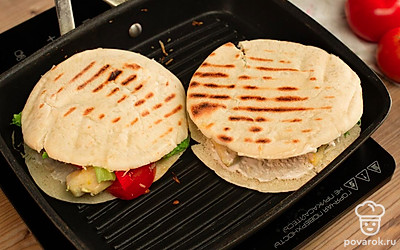 Питы смажьте соусом, выложите на них филе, присыпьте сыром, добавьте ромэн и овощи. Скрутите в рулеты и слегка обжарьте на сковороде.