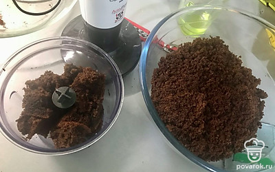 Кусочки бисквита пропускаем через измельчитель, делаем крошку. Далее к крошке добавляем сгущенку и перемешиваем.