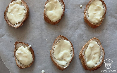 На застеленную пергаментной бумагой форму выложите хлеб. В каждое углубление равномерно распределите начинку из йогурта и желтка.