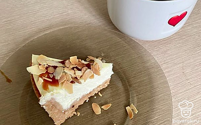 На ночь убрать в холодильник. Перед подачей полить карамелью и украсить поджаренной миндальной стружкой. Чизкейк станет лучшим украшением праздничного стола. Приятного аппетита.