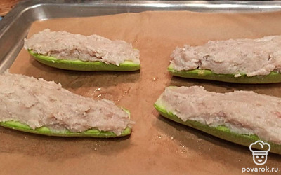 Разложите заготовки на пергаменте. Смажьте кабачки оливковым маслом. Серединку каждого кабачка заполните фаршем. 