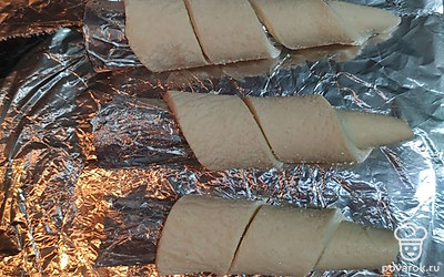Теперь обматываем трубочки из фольги тестом и смазываем яичным жёлтом, для красивого цвета.