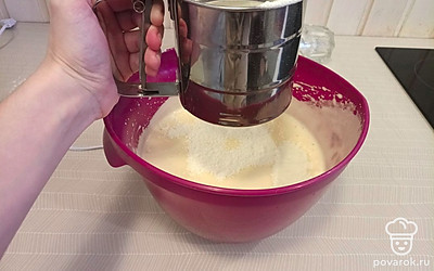 Просеиваем порционно муку в миску и сразу же перемешиваем. Мешаем аккуратно лопаткой, движениями от донышка вверх.