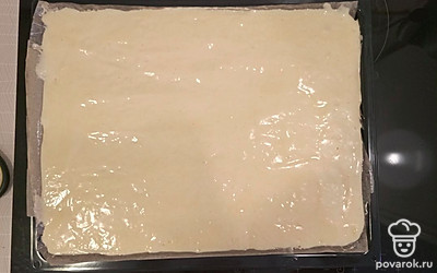 Стелим на противень пергаментную бумагу, смазываем маслом (10 гр). Выливаем тесто и равномерно распределяем.