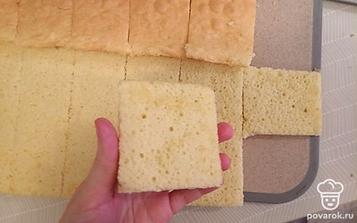 После того, как тесто приготовится, оставляем его на балконе минут на 10, чтобы оно остыло. Далее переворачиваем его из формы на доску, снимаем с него бумагу и начинаем разрезать на прямоугольники или квадратики так, чтобы получились пирожные, но пока без начинки. 