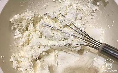 Приготовьте массу для чизкейка. Разотрите сыр с сахарной пудрой до растворения сахара, добавьте сметану и сливки и перемешайте до однородности. Поочередно добавляйте яйца и перемешивайте. Положите крахмал и ваниль, в конце добавьте сок лимона и цедру. Перемешайте.