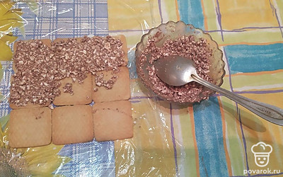 9 штук печенья обмакните с двух сторон в молоко и выложите на пищевую пленку или лист плотной бумаги плотно друг к другу, сформировав квадрат 3 на 3. Нанесите первый слой творога. Повторите слой печенья и слой творога еще два раза.