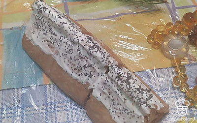 Достаньте изделие из холодильника. Отогните края пленки. Промажьте верх «хуторка» творогом без какао. Обсыпьте маком, как на фото. 