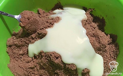 Немного размяв вилкой масло по печенью, влейте 1/2 банки сгущённого молока и начните вымешивать ложкой. Когда масса станет более сухой, добавьте оставшееся сгущённое молоко. Продолжайте вымешивать ложкой. Когда масса станет похожа на мокрый песок, начните вымешивать руками. 