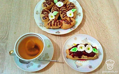 Заварные пирожные выложите на блюдо. Украсьте глазурью по вашему вкусу, тертым шоколадом. Положите свежие ягоды, цукаты, веточку мяты.