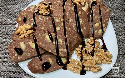 Сладкую шоколадную колбаску порежьте порционными кусочками. Украсьте ягодами, мятой. Подайте чай, кофе или какао.