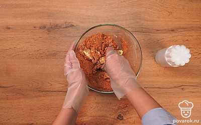 Начните готовить пирожное "Картошка" из сухарей со сгущенкой. Переложите измельченные сухари в глубокую миску. Добавьте какао-порошок и перемешайте. Добавьте сгущенное молоко. Перемешайте сухари со сгущенкой и добавьте размягченное сливочное масло. Перемешивать ингредиенты лучше руками до тех пор, пока масса не станет липкой и не перестанет рассыпаться.