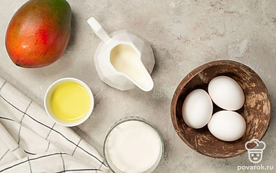 Манго помойте, удалите косточку и кожуру. Куриные яйца помойте, отделите желтки от белков. Вымойте апельсин, разрежьте его пополам. С половины снимите цедру мелкой теркой, вторую половину нарежьте полукруглыми дольками. Подготовьте миксер.