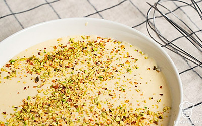 Подготовьте основу мороженого. Взбейте яйцо с сахаром до однородной массы. 250 мл сливок подогрейте до горячего состояния, но не кипятите. Постепенно введите горячие сливки в яичную массу, не переставая перемешивать. Оставшиеся сливки взбейте в густую пену. Соедините все ингредиенты в одной емкости, добавив измельченные фисташки. Поместите полученную смесь в морозильную камеру на 4 часа.