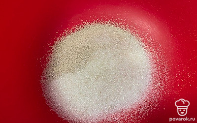 В глубокой чаше смешайте сахар и сухие дрожжи.