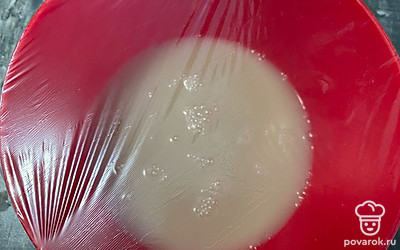 Подогрейте воду до 35-38 градусов и влейте в чашу. Тщательно перемешайте до растворения сахара и дрожжей. Накройте пленкой и уберите в теплое место на 8-10 минут.