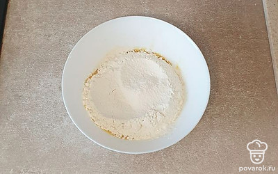 Затем к яйцу просейте половину муки и перемешайте.