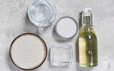 Разогрейте воду, чтобы она стала теплой. Просейте муку. Подготовьте пищевую пленку и скалку.