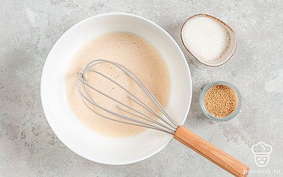 Слегка взбейте яйцо и влейте в него чуть подогретое молоко. Всыпьте дрожжи и сахар, перемешивайте до растворения кристалликов. Влейте масло и снова перемешайте.