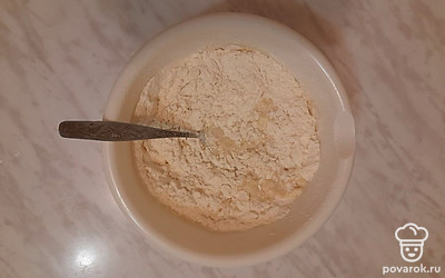 Влейте смесь в просеянную муку.