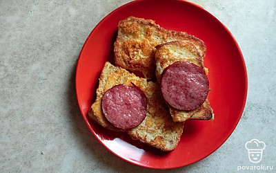 Выложите сверху колбасу. Вкусный сырный завтрак готов.